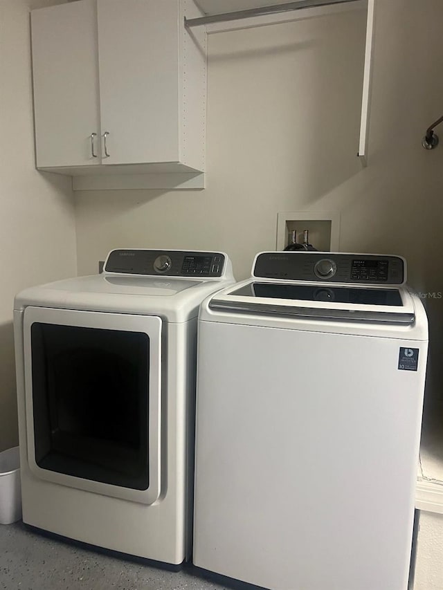 clothes washing area featuring cabinet space and independent washer and dryer