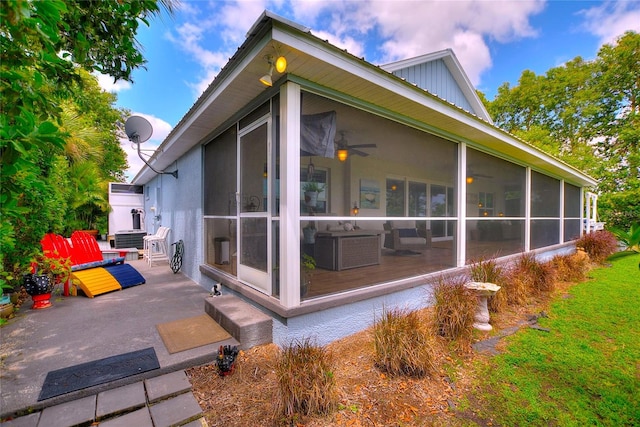 exterior space featuring central air condition unit, a patio, board and batten siding, and a sunroom