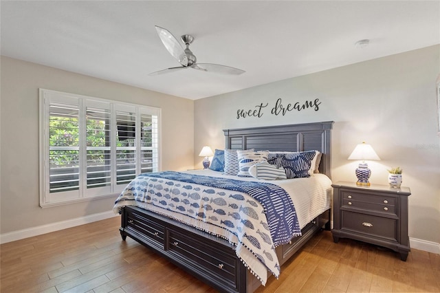 bedroom with a ceiling fan, baseboards, and light wood-type flooring