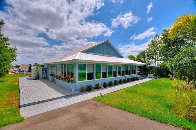 view of side of home featuring a lawn and metal roof