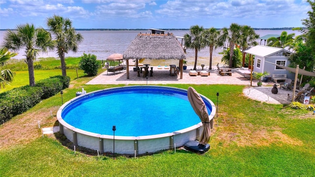 pool featuring a lawn, a water view, a gazebo, and a patio