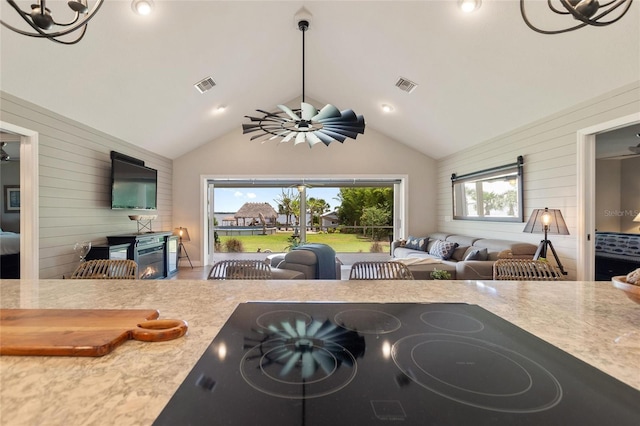 1395 S Lake Reedy Blvd, Frostproof, FL 33843 - living area with a lit fireplace, wooden walls, lofted ceiling, and a chandelier