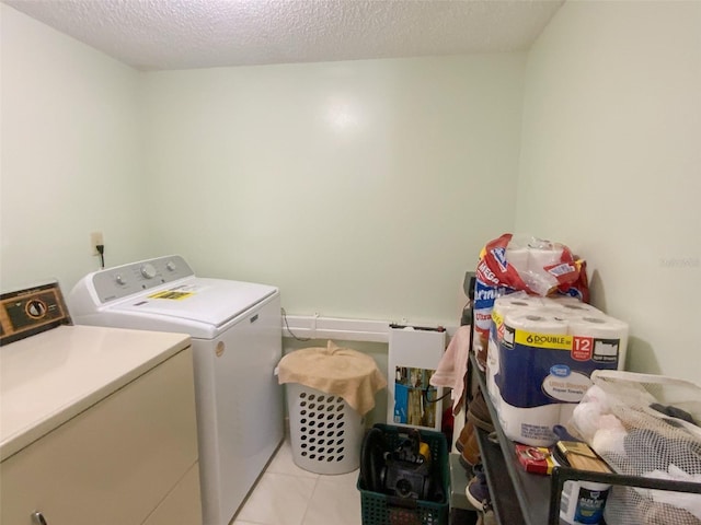 2643 Pine Ridge Way S Unit A1, Palm Harbor, FL 34684 - laundry room featuring a textured ceiling, independent washer and dryer, light tile patterned floors, and laundry area
