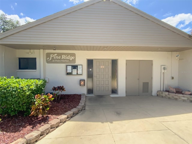 2643 Pine Ridge Way S Unit A1, Palm Harbor, FL 34684 - exterior space featuring stucco siding and a porch