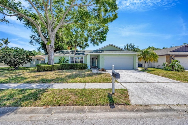 single story home featuring a garage, a front lawn, and concrete driveway