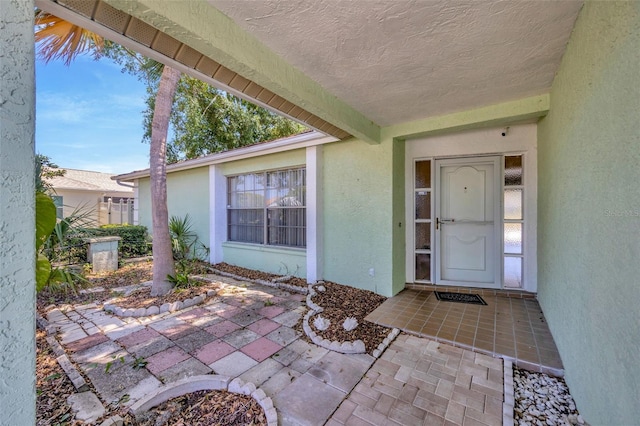 property entrance featuring a patio and stucco siding