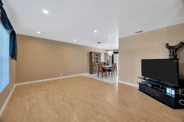 living room featuring visible vents, wood finished floors, baseboards, an inviting chandelier, and recessed lighting