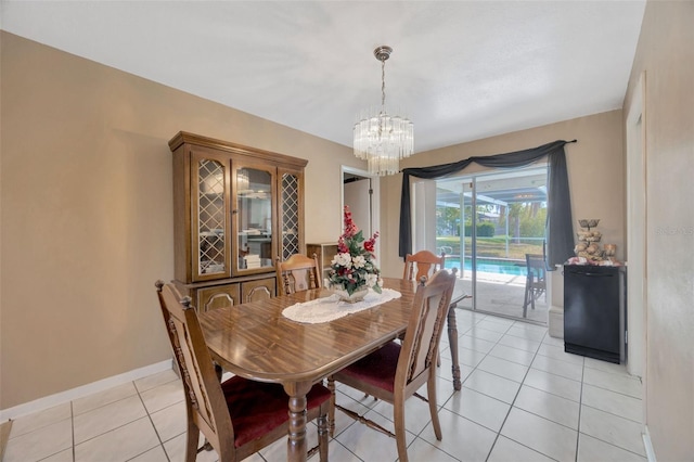 dining space featuring an inviting chandelier, baseboards, and light tile patterned flooring