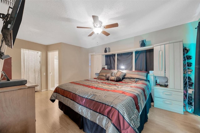 bedroom featuring a textured ceiling, a ceiling fan, and wood finished floors