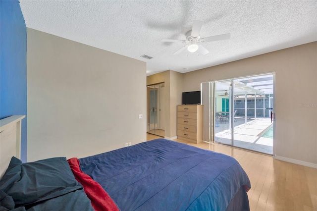 bedroom featuring visible vents, access to exterior, baseboards, light wood-type flooring, and a textured ceiling