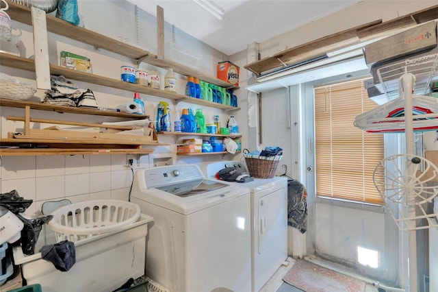 clothes washing area with independent washer and dryer, laundry area, and tile walls