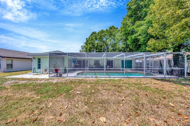 back of house featuring stucco siding, an outdoor pool, a patio area, a lawn, and a lanai