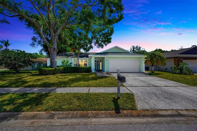 ranch-style home with an attached garage, driveway, and a front yard