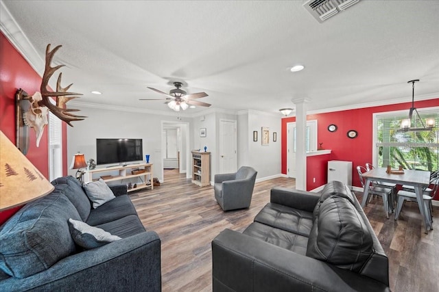 living room with wood finished floors, ornate columns, baseboards, visible vents, and a ceiling fan