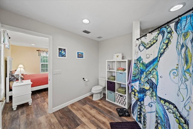 bathroom with connected bathroom, visible vents, baseboards, toilet, and wood finished floors