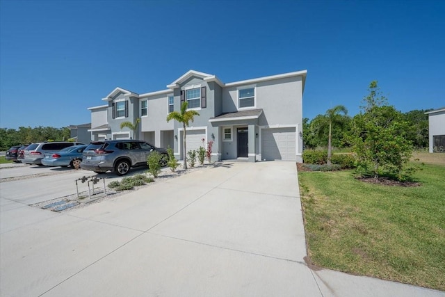 view of front of home with a garage, stucco siding, a front yard, and concrete driveway