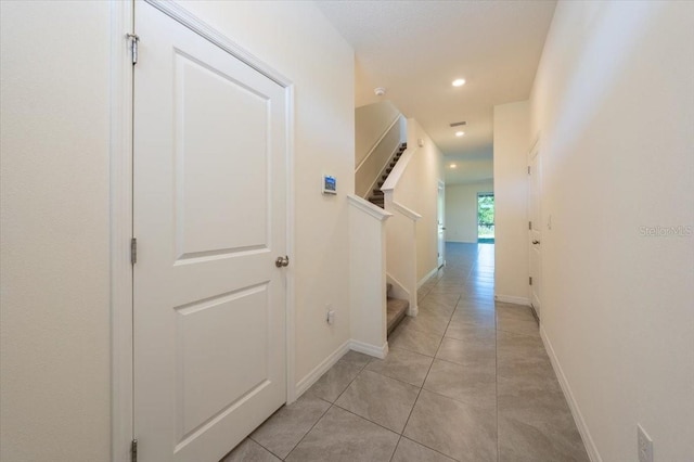 hall with recessed lighting, stairs, baseboards, and light tile patterned floors