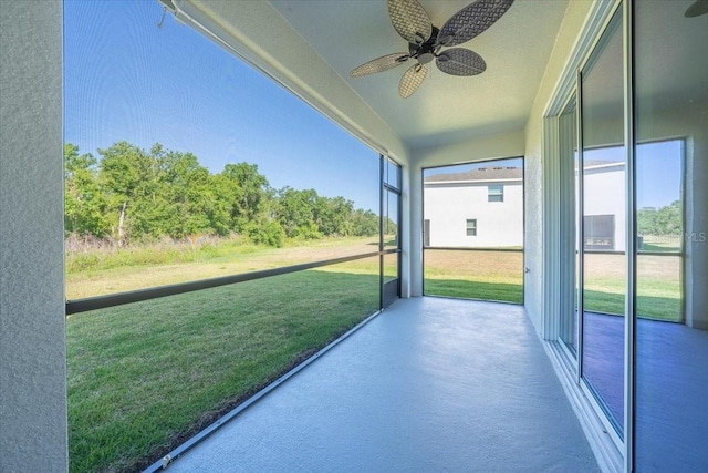 unfurnished sunroom with a ceiling fan