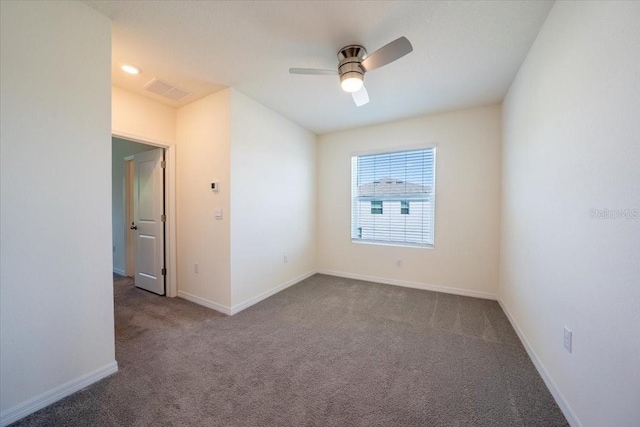 carpeted empty room featuring ceiling fan and baseboards