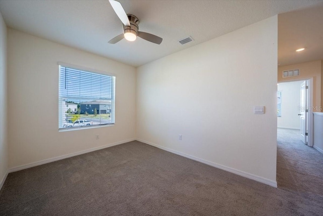 unfurnished room with baseboards, ceiling fan, carpet flooring, and visible vents