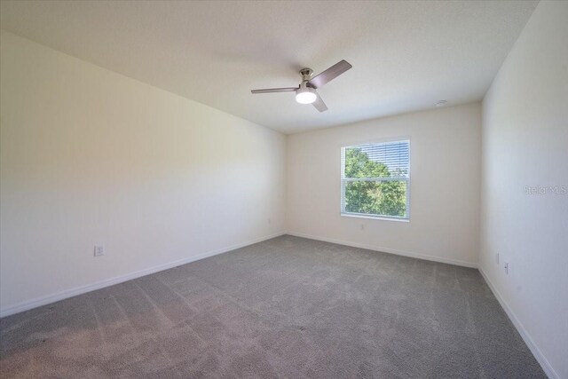 empty room with baseboards, a ceiling fan, and carpet