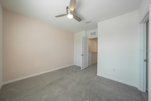 unfurnished bedroom with light colored carpet, baseboards, visible vents, and a ceiling fan
