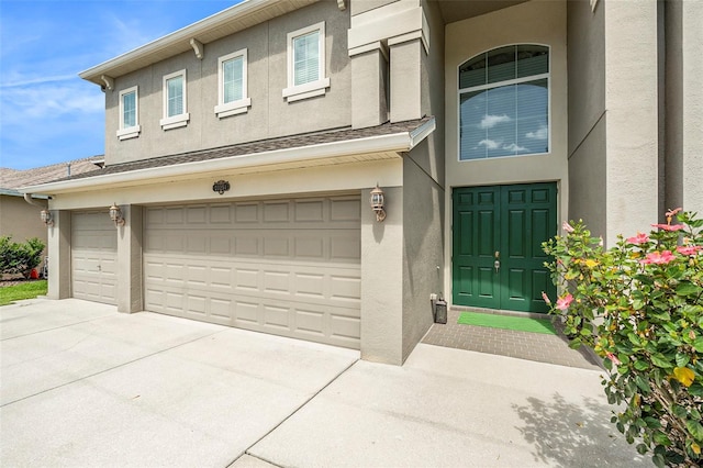 exterior space with an attached garage, driveway, and stucco siding