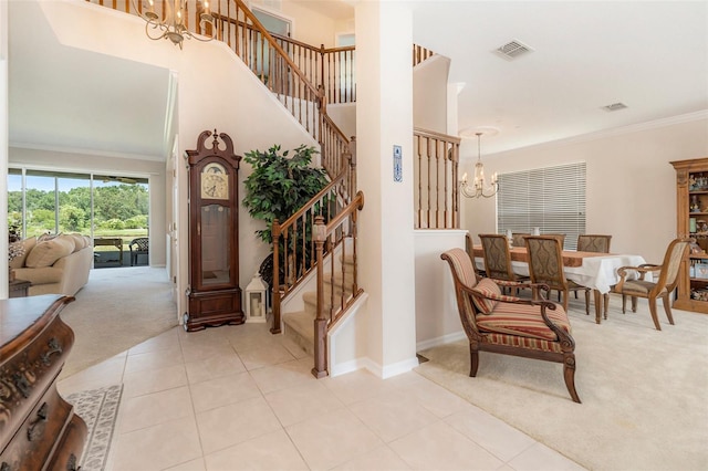 entryway with crown molding, stairway, an inviting chandelier, light carpet, and light tile patterned flooring