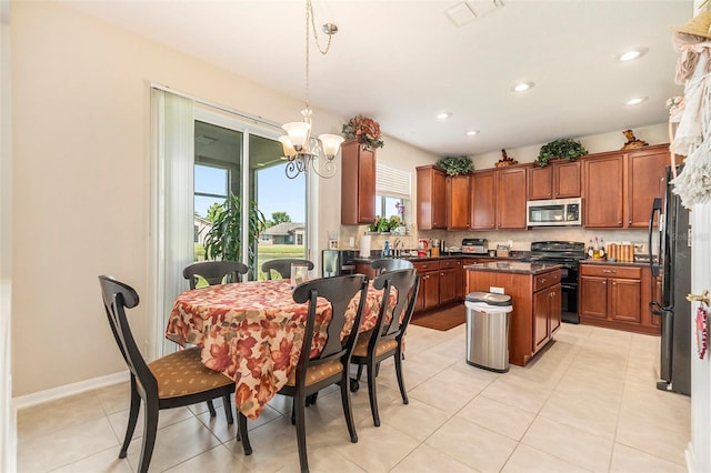 kitchen featuring visible vents, dark countertops, a center island, black appliances, and a notable chandelier