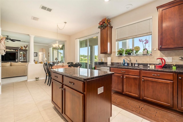 kitchen with visible vents, a sink, an inviting chandelier, and tasteful backsplash