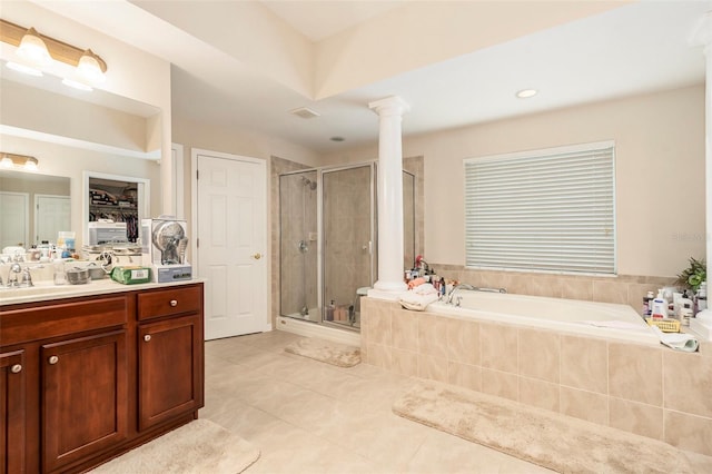 full bath featuring a garden tub, a stall shower, vanity, tile patterned floors, and ornate columns