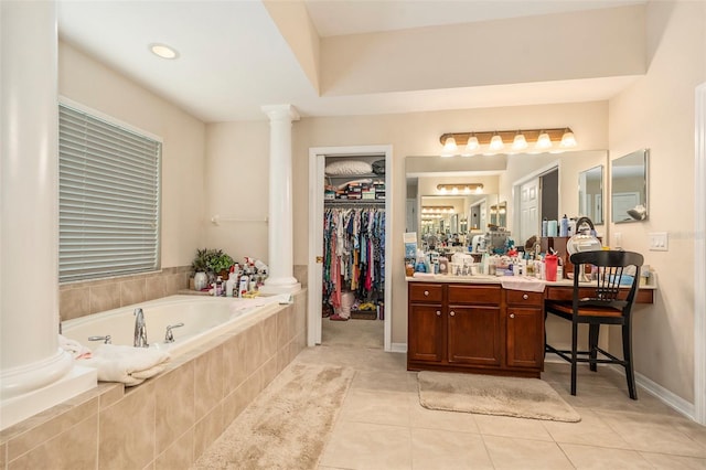 bathroom with vanity, a walk in closet, ornate columns, a bath, and tile patterned floors