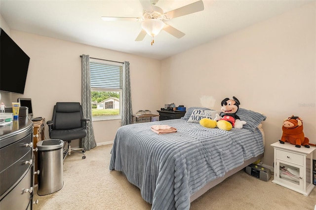 bedroom featuring light colored carpet, baseboards, and ceiling fan