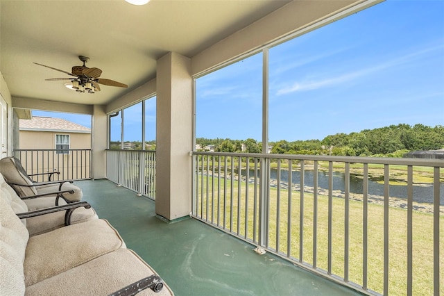 sunroom / solarium with a water view and ceiling fan
