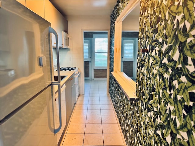 5660 80th St N Unit C101, Saint Petersburg, FL 33709 - kitchen featuring freestanding refrigerator, modern cabinets, light tile patterned floors, and white microwave