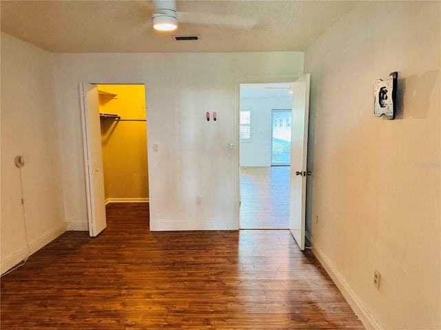 5660 80th St N Unit C101, Saint Petersburg, FL 33709 - unfurnished bedroom featuring a walk in closet, baseboards, wood finished floors, visible vents, and a closet