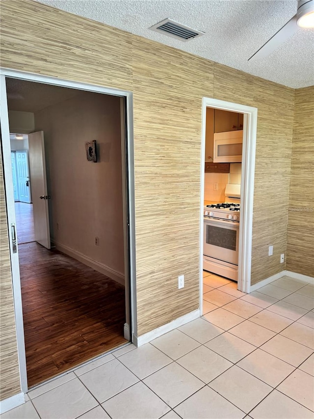 5660 80th St N Unit C101, Saint Petersburg, FL 33709 - hallway with light tile patterned floors, baseboards, a textured ceiling, and visible vents