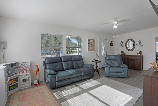 living area with wood finished floors and a ceiling fan