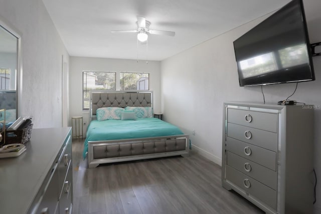 bedroom featuring baseboards, wood finished floors, and ceiling fan
