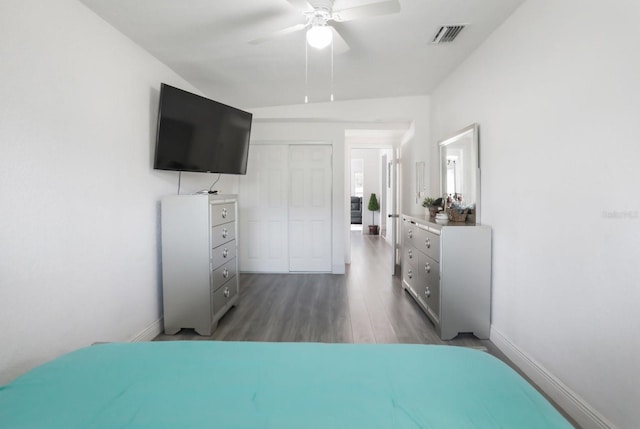 bedroom with a closet, ceiling fan, visible vents, baseboards, and wood finished floors