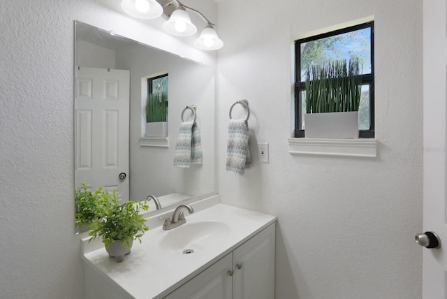 bathroom featuring a textured wall and vanity