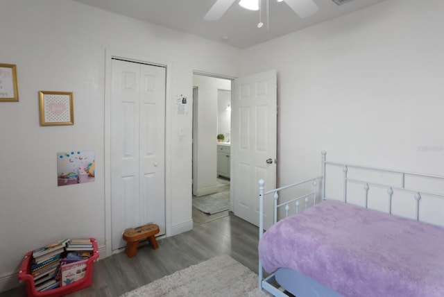 bedroom with wood finished floors, a ceiling fan, visible vents, and a closet