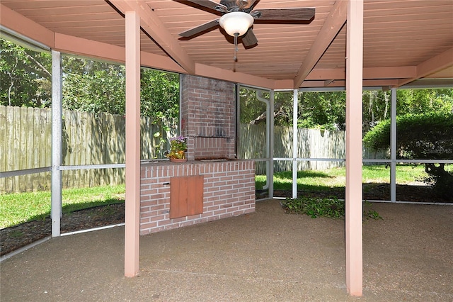 unfurnished sunroom with a ceiling fan and beam ceiling