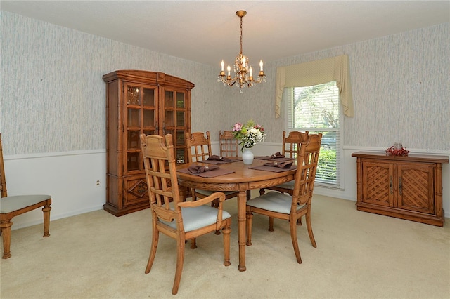 dining space featuring carpet floors, wallpapered walls, a notable chandelier, and wainscoting