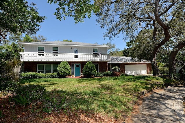 view of front property featuring brick siding, a garage, and a front yard