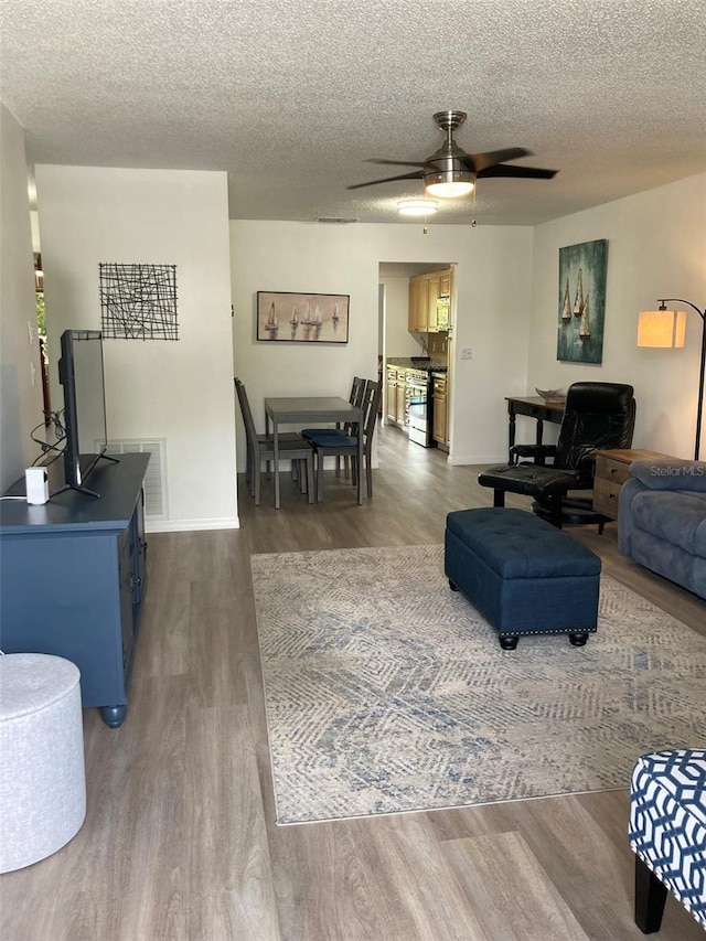 7951 58th Ave N Unit 308, Saint Petersburg, FL 33709 - living area featuring ceiling fan, wood finished floors, a textured ceiling, and baseboards