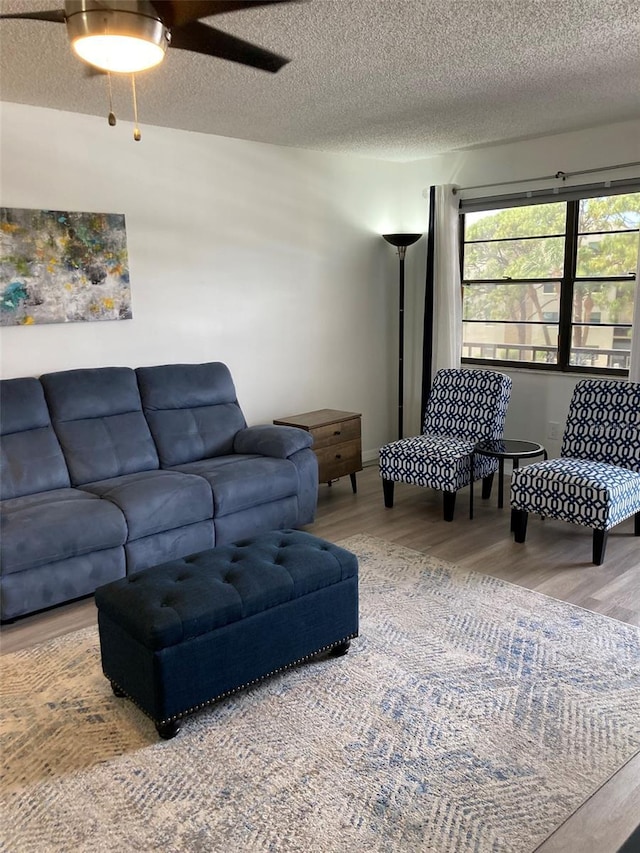 7951 58th Ave N Unit 308, Saint Petersburg, FL 33709 - living area with wood finished floors, a textured ceiling, and a ceiling fan