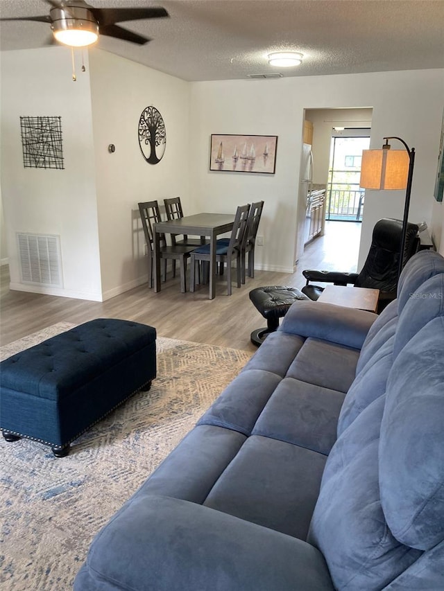 7951 58th Ave N Unit 308, Saint Petersburg, FL 33709 - living area with ceiling fan, wood finished floors, baseboards, and a textured ceiling