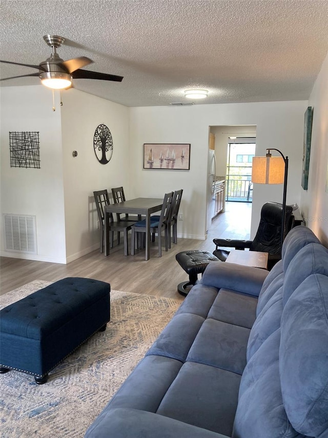 7951 58th Ave N Unit 308, Saint Petersburg, FL 33709 - living room with a ceiling fan, wood finished floors, a textured ceiling, and baseboards