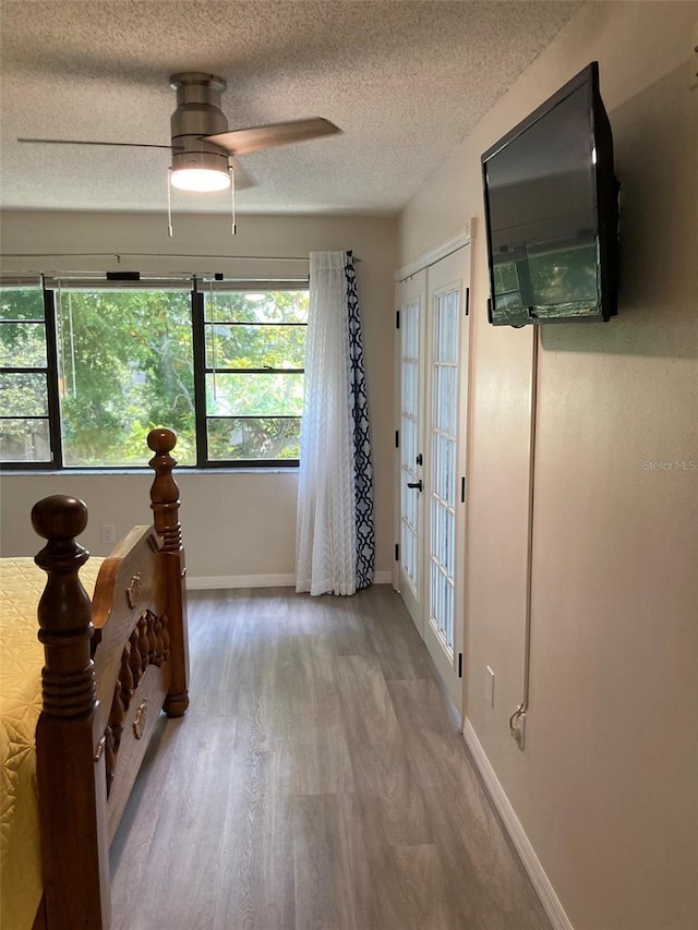 7951 58th Ave N Unit 308, Saint Petersburg, FL 33709 - corridor with wood finished floors, a textured ceiling, and baseboards